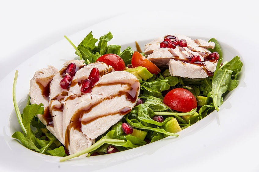 Salad with chicken with pomegranate sauce on a white background Salad with chicken with pomegranate sauce on a white background