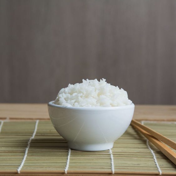 Jasmine rice in white cup On a bamboo mat