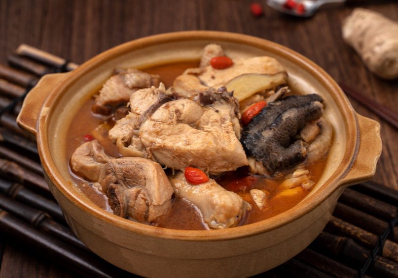Taiwanese homemade delicious sesame oil chicken soup food in a bowl on dark wooden table background.